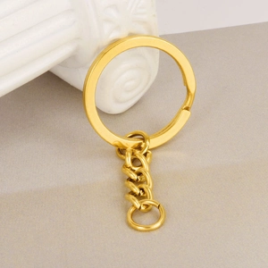 Polished 18K gold-plated stainless steel key ring with short link chain on a white pedestal