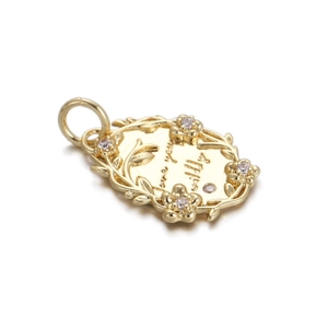 Golden oval pendant with floral relief and sparkling rhinestones featuring Willy engraving