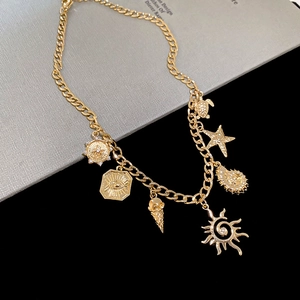 Detail of gold Cuban chain necklace with sea charms including starfish and turtle pendants