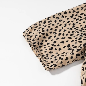 Detail view of elastic cuff with leopard print on vintage satin wrap dress