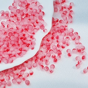 Macro detail of 6mm frosted pink and red gradient glass beads for DIY jewelry making