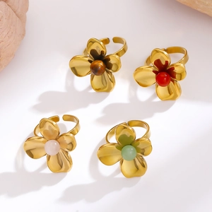 Detail of four gold-plated floral rings featuring colorful bead centers and hollow petals