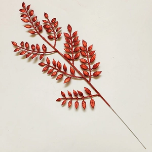 Dettaglio di rami di foglie rosse glitterate per decorazioni natalizie festive in casa