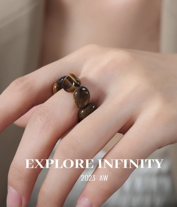 Detail of beaded tiger eye stone ring with elastic cord on a hand from the 2023 AW series