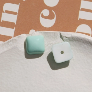 Macro shot of square pastel resin beads in mint green and white for DIY jewelry making