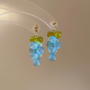 Detail of grape-shaped resin drop earrings with blue beads and gold needle posts