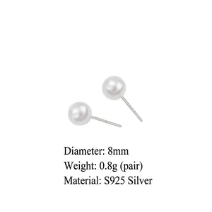 Close-up of elegant 8mm round white pearl earrings with silver needles on plain background