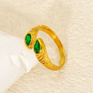 Detail of gold spiral ring featuring dual pear-cut green zircon stones in close-up