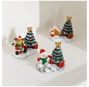Detailed view of resin Christmas miniatures with reindeer, snowman, and gingerbread house
