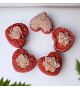 Detail of woven heart-shaped rose candles with intricate textures and cotton wicks