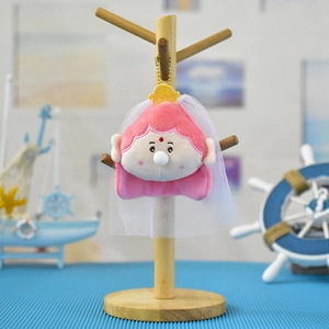 Vista detallada de un lindo llavero de Buda de peluche rosa con velo y burbuja nasal.