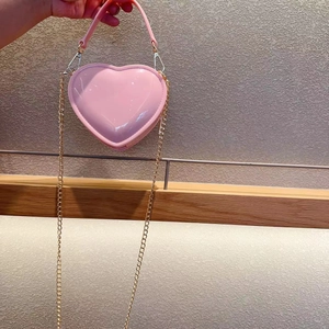 Detailed shot of a pink heart-shaped mini jelly bag with gold chain and handle