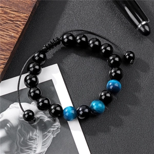 Macro detail of 10mm tiger eye beads and black glass beads on adjustable woven bracelet