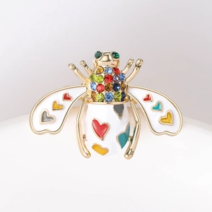 Detailed macro shot of honey bee brooch with colorful enamel hearts and sparkling rhinestones