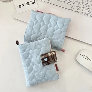 Detail of light blue quilted heart pouch for small items near a laptop and mouse