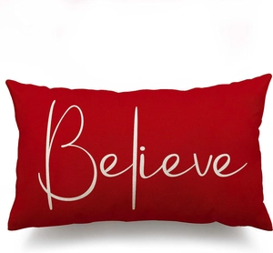 Detail of red linen Christmas pillowcase with white Believe text and woven texture