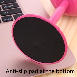 Pink tumbler base with non-slip pad on light wood desk and laptop background