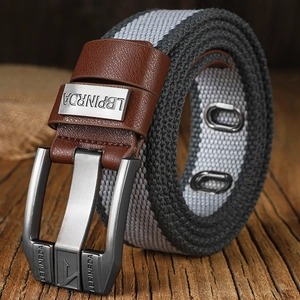 Gray canvas belt with brown leather trim and silver metal pin buckle on wooden table