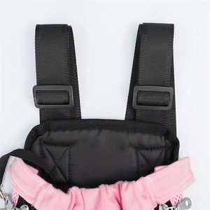 Detail view of pink pet carrier with adjustable nylon straps and black plastic buckle