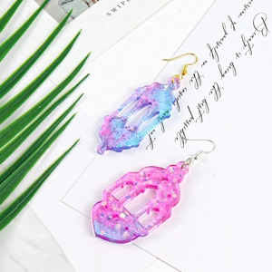 Detail of hollow lantern resin earrings with purple gradient and glitter on display card