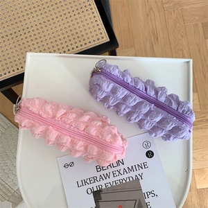 Detail of pink and purple bubble textured stationery bags with metal ring zippers on tray