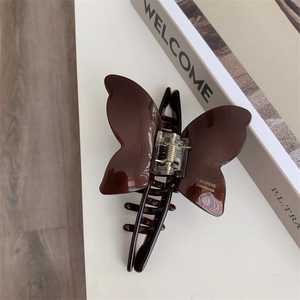 Detailed view of the dark brown amber-textured acetate butterfly hair claw clip
