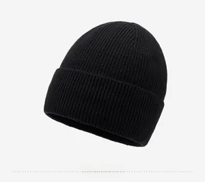 Close-up of black ribbed knit beanie featuring a premium oval metal logo on the cuff