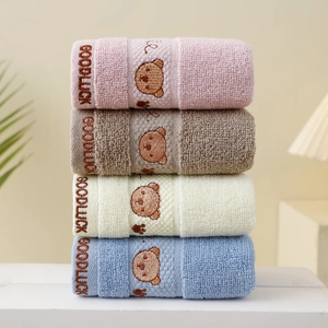 Close-up of soft cotton children towels with teddy bear embroidery and Goodluck text