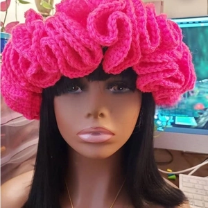 Detail of rose pink crochet ruffled knit hat with layered wavy pleated brim design