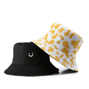 Cappello da pescatore reversibile con stampa mucca e faccina sorridente in nero e giallo