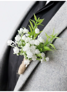 Detail of white babys breath boutonniere with twine wrap on a gray wool suit lapel