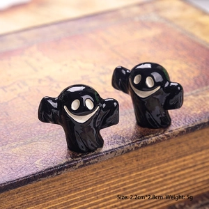 Detailed view of mini 3D glossy ghost figurines on a vintage book for Halloween decor