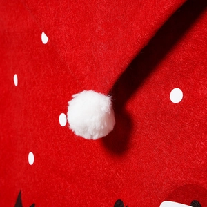 Detail of red non-woven fabric Christmas chair cover with white dots and soft pompom