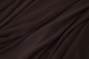 Macro detail of the sheer chocolate brown fabric with elegant pleated texture and soft drape