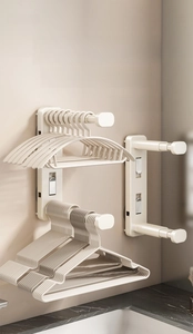 Macro detail of cream-colored telescopic wall rack showing three-stage adjustment feature