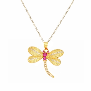 Détail d'un pendentif libellule dorée orné de pierres rouges et de zircons blancs brillants