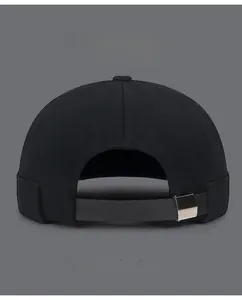 Détail de la sangle en cuir réglable et boucle argentée sur le bonnet en coton noir