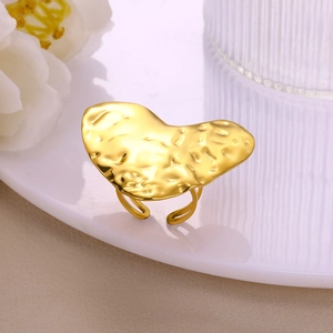 Detailed view of gold heart ring with hammered texture on an elegant white background