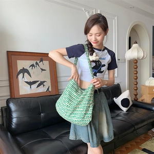 Detailed view of green and cream floral knit tote bag worn as a shoulder crossbody bag