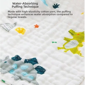 Close-up of baby gauze towel featuring bubble texture and cartoon dinosaur patterns