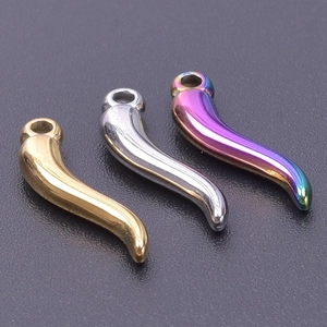 Macro shot of chili horn pendants in gold, silver, and rainbow stainless steel finishes