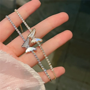 Close-up of sparkling gold and silver butterfly bracelets with pavé zircons and shell inlay