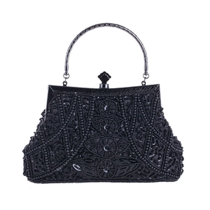 Dettaglio di ricamo con perline nere e paillettes su borsa da sera vintage con manico