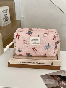 Detail of pink quilted cosmetic bag with cute cartoon animal prints and zipper closure