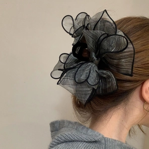 Large black organza bow hair claw clip for women's bun hairstyles in a vertical back view