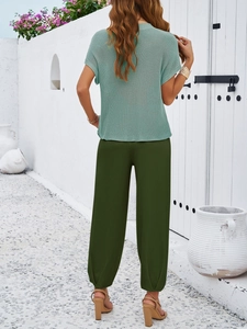 Back view of light green knit short sleeve top and dark green casual pants set for women