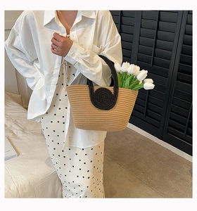Close-up of contrast woven cotton rope tote bag featuring a black round handle base detail