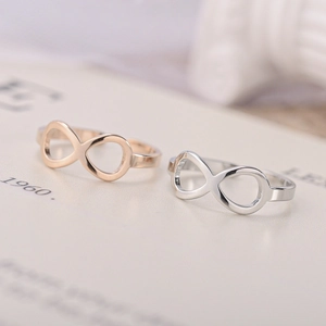 Macro view of rose gold and silver infinity rings resting on a book page