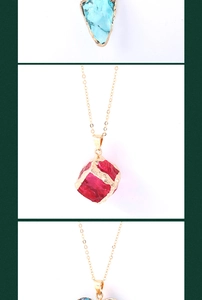 Macro shot of colorful raw crystal pendants with gold edges on delicate gold chains