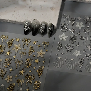 Close-up of bow and butterfly nail stickers with gold metallic embossed textures